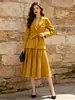 Traje de dos piezas para mujer con falda plisada, estilo para ir al trabajo, cintura ajustada, chaqueta de manga larga con detalle de corbata y falda larga. Venta al por mayor transfronteriza, disponible en 12 colores