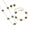 Conjunto de tres piezas de la suerte estilo europeo y americano: conjunto vintage de collar, aretes y pulsera de trébol de cuatro hojas en negro y dorado. Accesorios versátiles para el trayecto al trabajo al por mayor