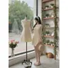 Vestido sin mangas de gasa blanca con lazo en la espalda, ceñidor de cintura, falda corta