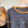 Clásica y versátil, esta camiseta de manga larga a rayas, con detalles en naranja, elástica, cómoda y suave, es perfecta como capa base o como top para principios de otoño para mujer.
