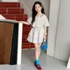 Conjunto de Verão para Meninas Estilo Universitário 2026 Novo Modelo para Crianças Maiores, Blusa com Gola Polo de Renda, Saia Curta, Saia em Camadas