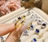 Anel Camélia Palácio Antigo Pequeno e Exquisito Pequeno Diamante Quebrado Feminino Banhado a Ouro 18K Design de Nicho Anel Aberto Corindo Azul