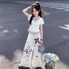 Conjunto de dos piezas a la moda estilo universitario para niños de mediana edad y mayores: camiseta polo de manga corta a rayas y patchwork y pantalones casuales anchos con ribete de encaje