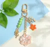 Llavero de Flor de Hilo de Colores con Cuentas Flor Azul Fresca Ramas y Hojas de Rosa Llavero de Metal Encanto de Bolso Suave y Femenino