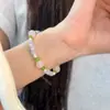 Pulsera artesanal de cristal rosa natural y peridoto con colores contrastantes de flor de durazno y guayaba, efecto ojo de gato, dulce y a la moda