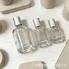 Frasco de perfume de vidro transparente com listras verticais e corpo redondo simples, frasco spray com tampa prateada, fundo grosso, frasco cosmético de viagem