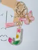 Suministros del Fabricante Llaveros con Flores Secas Prensadas 26 Letras del Alfabeto Inglés Llaveros con Borla de Mariposa Charms para Bolsos de Mujer