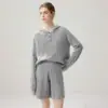 Un atuendo elegante inspirado en el estilo "old money", que presenta un top de punto trenzado con cuello mao, combinado con shorts de punto de cachemira holgados, casuales y relajados.