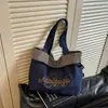 Bolsa de mano retro de mezclilla bordada estilo coreano con un ambiente relajado y casual, con un diseño de patchwork a cuadros azules, perfecta para que los estudiantes universitarios la lleven a clase