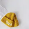 Chapéus Infantis Outono e Inverno Novos Versáteis Chapéus com Proteção de Orelha para Meninos e Meninas, Gorros de Tricô com Letras, Chapéus de Bebê, Gorros