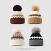 Nueva Colección Invierno 2026: Gorro Grueso de Lana Tejido Jacquard con Patrón de Diamantes en Bloques de Color y Pompones para Calidez y Protección de Orejas