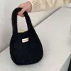 Bolso de mano suave y mullido estilo coreano para mujer, perfecto para otoño e invierno, bolso tote de punto versátil de color liso, ideal para el uso diario y salidas casuales, con correa de muñeca peluda