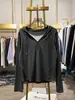 Camiseta de manga larga con capucha estilo americano de dos piezas falsas para mujer, primavera y otoño, versión coreana, corte holgado, adelgazante, top de capa base con un diseño elegante