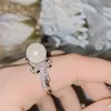 Anillo Versa de borla de lazo asimétrico con perla negra, anillo Tahidi de cuentas de concha marina barroca con circón