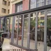 Puerta plegable Puerta divisoria Habitación de lavado de autos de alta resistencia Fachada de tienda Tienda Ventana plegable Puerta corrediza Balcón Puerta corrediza de aleación de aluminio