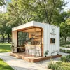 Contenedor curvo de puerta de entrada blanco y marrón de lujo ligero para cafetería con mesas y sillas al aire libre, una tienda de ocio sencilla y moderna en el parque
