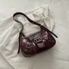 Bolsa transversal de ombro versátil com tachas plissada 2026 novo modelo de luxo para o dia a dia bolsa de mão estilo motociclista bolsa meia-lua