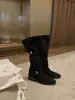 Versão em couro de botas de montaria femininas com aumento de altura que fazem as pernas parecerem mais longas, botas longas de bico redondo com salto grosso e fivela de tira cruzada, botas de cowboy western