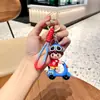 Colgante de llavero de mochila de pareja de dibujos animados exquisito, colgante para niños y niñas ciclistas, muñeca de PVC, pequeños regalos al por mayor