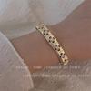 Pulsera de circonitas de cuatro pétalos de estilo lujoso y ligero para mujer, elegante y súper brillante, con un toque retro de alta gama.