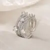 Elección artística: Anillo de junta cruzada con incrustaciones de diamantes, anillo retorcido de nicho para el trayecto diario, anillo hueco multicapa apilable de circonita