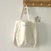 Bolsa de lona bordada con letra única y fresca, gran capacidad, sensación relajada, versátil para el uso diario y el trabajo, bolsa de tela de un solo hombro
