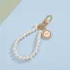 Chaveiro de pulseira de pérola estilo Chanel para meninas com laço em formato de coração, flor e pingente de metal acessório de bolsa