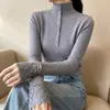 Camisa de nuevo estilo con mangas huecas y cuello semi-alto, con artesanía hecha a mano, costuras de encaje a la moda, diseño ajustado, suéter de punto para mujer