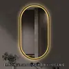Espejo de baño inteligente ovalado en stock con lijado exterior e iluminación LED translúcida, adecuado para montaje en pared de baño y proyectos hoteleros, con opciones de personalización.