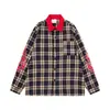 Camisa masculina de manga longa xadrez azul marinho com gola vermelha, apresentando um design punk street style escuro com patches de chama e estrela, e um corte solto
