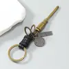 Llavero de metal vintage minimalista con colgante de cordón de cuero tejido, accesorio de llavero creativo unisex