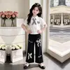 Conjunto de dos piezas de verano único para niñas estilo coreano 2026: camiseta casual de manga corta y pantalones anchos de encaje fino y elegantes
