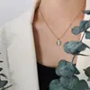 Collar de acero y titanio con colgante ovalado de ojo de gato de cadena de clavícula de oro de 18 quilates de alta gama de estilo retro francés para mujer