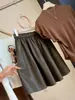 Moderna falda de botón de cuero PU para mujer, nuevo estilo otoño 2026, elegante falda de línea A elástica de cintura alta que disimula y estiliza la figura