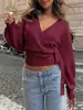 Top de punto ajustado con cuello en V cruzado estilo europeo y americano para otoño e invierno, top corto elegante irregular con corbata para mujer al por mayor