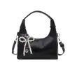 Bolso de axila moderno y artístico de estilo coreano con forma de media luna, con colgante de lazo en forma de corazón de perla, correa de hombro ajustable, bolso de hombro único para mujer
