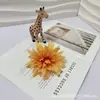 Venta al por mayor del fabricante Crisantemo de Llama Simulada Aguja de Pino Cabeza de Crisantemo Pinza de Cangrejo Flor Falsa Decoración Accesorios para Pasador de Cabello Flor Falsa