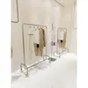 Tienda de Ropa Colgador de Ropa de Acero Inoxidable con Ruedas Plata Exhibidor de Isla de Piso Estante Exhibidor para Tienda de Ropa de Mujer