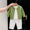 Conjunto de dos piezas para niño estilo coreano, otoño 2026: suéter verde de punto trenzado, chaqueta versátil para niños y pantalones casuales blancos.