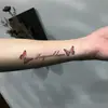 Adesivo de tatuagem borboleta com gradiente rosa claro, à prova d'água e duradouro, adesivo de tatuagem caligráfico suave para o pulso