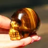 Pedra Bruta de Cristal Natural Polida Modelo de Caveira de Olho de Tigre Amarelo com Efeito Olho de Gato Pequena Estátua Ornamento de Decoração para Casa Atacado