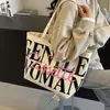 Bolsa Versátil Ins para Commuter Bolsa Tote de Lona Grande Capacidade com Letras para Mulheres Nova Bolsa de Lona de Nicho Tailandês 2025