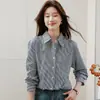 Foto real de camisa de rayas azules, moda femenina nueva de otoño 2026, hombros ligeramente caídos, de un solo botón, cuello camisero, top casual elegante
