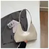 Venta al por mayor transfronteriza de bolsos nuevos de charol de alta gama con forma de media luna para debajo del brazo, bolsos de mano de nicho estilo francés para salidas y bolsos de hombro para el trabajo.