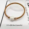Nueva cuerda para el pelo simple de perlas, diadema, banda elástica, cuerda para la cabeza con cubierta de cuero para mujer, versión coreana de Banda Elástica al por mayor, anillo para el pelo de alta elasticidad