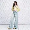 Jeans casual feminino de cor azul escuro, com lavagem e aspecto desgastado, cintura alta, modelo novo para o início do outono de 2026, corte solto, modelador e com bom caimento.