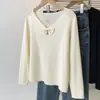 Suave jersey de punto color albaricoque con cuello en V y cuello de lazo, diseñado para primavera, otoño e invierno 2026, en un corte holgado talla grande.