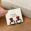 Brincos de Agulha Prata Vazados em Forma de Coração Estilo Retrô para Mulheres, Adequados para o Ano Novo, com um Design Vermelho Simples e Estilo Exquisito de Hong Kong para Outono e Inverno