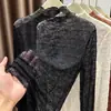Procesamiento PersonalizadoBlusa de encaje de manga larga, cuello medio alto, corte ajustado, transparente, con bordes de volantes para mujer. Fuente OEM/ODM