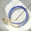 O dono da loja recomenda muito um colar de pérolas de água doce naturais de alta qualidade e cristais coloridos artificiais para o verão.
